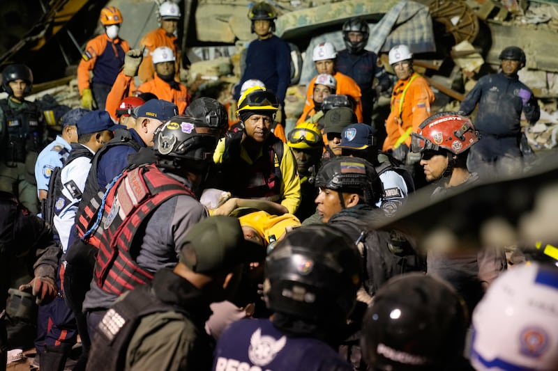 Rescue workers search through the rubble of a collapsed building in Caracas. Photograph: Ariana Cubillos/AP