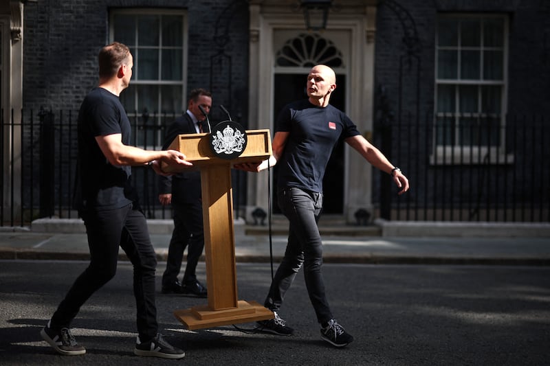 Members of staff bring the lectern outside Number 10 Downing Street. Photo: Henry Nicholls/AFP via Getty Images