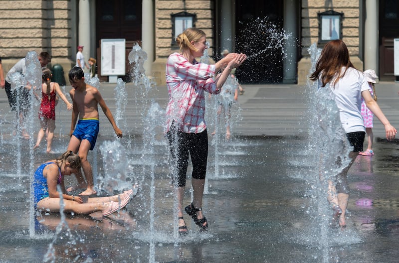 People cool themselves in a fountain in front of the Theatre of Opera and Ballet in Lviv, western Ukraine, amid the ongoing Russian invasion. Photograph: EPA