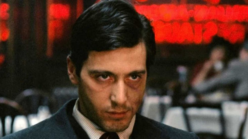 Al Pacino as Michael Corleone glaring at a restaurant in The Godfather