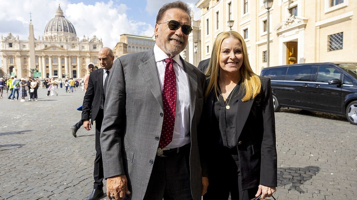 Arnold Schwarzenegger and Heather Milligan posing in St. Peter's Square at the Vatican