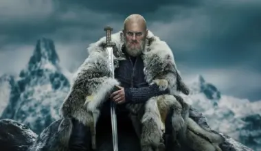 Bjorn Ironside, a character from Vikings stares into the camera holding his sword.