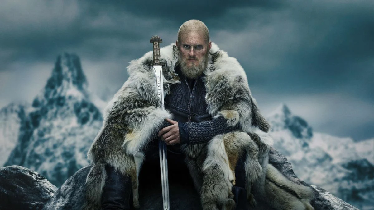 Bjorn Ironside, a character from Vikings stares into the camera holding his sword.
