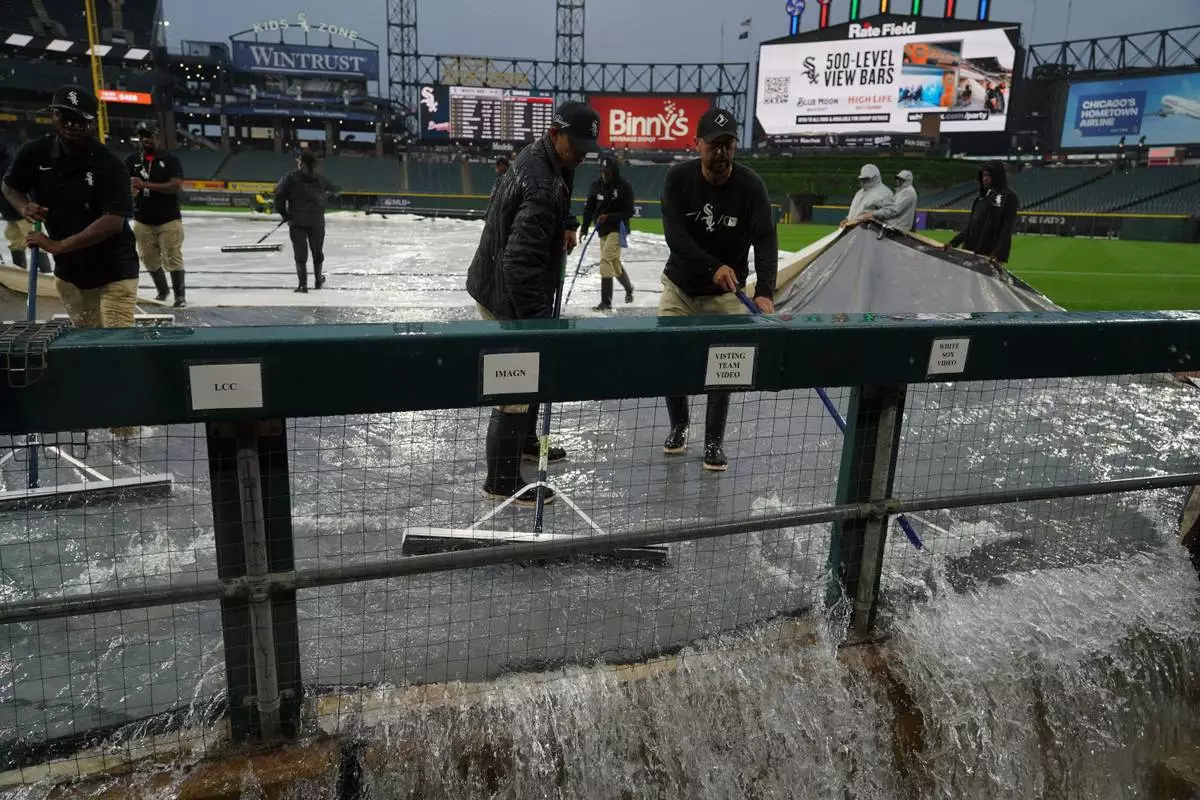 Grounds crew remove water from the field after severe thunderstorms came through the Chicago area before a baseball game between the Chicago White Sox and the Atlanta Braves, Wednesday, June 10, 2026, in Chicago. (AP Photo/David Banks)