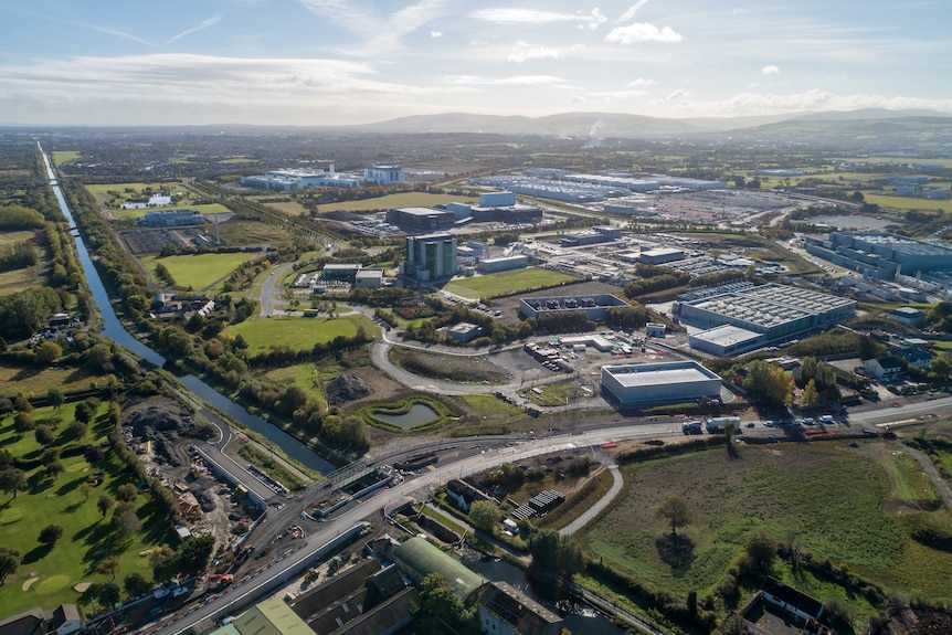 Aerial view of a sprawling business park with a river in view and residential areas.