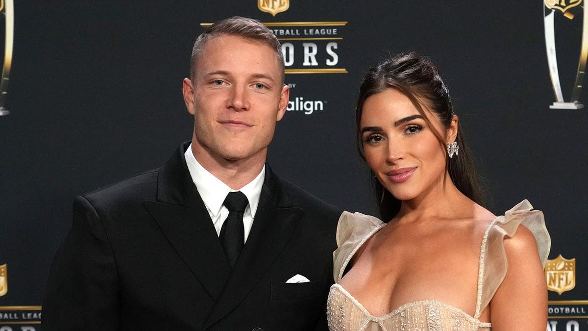 Christian McCaffrey and Olivia Culpo standing together at Symphony Hall in Phoenix, Arizona.