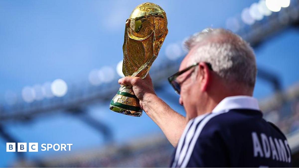 A Scotland supporter raises a replica FIFA World Cup Trophy in the stands prior to during the Group C match against Morocco