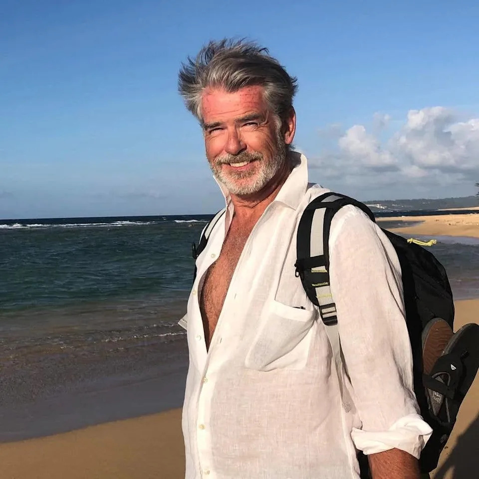 Pierce Brosnan poses for a photo on the beach, taken and shared by his wife Keely Shaye Brosnan on Instagram