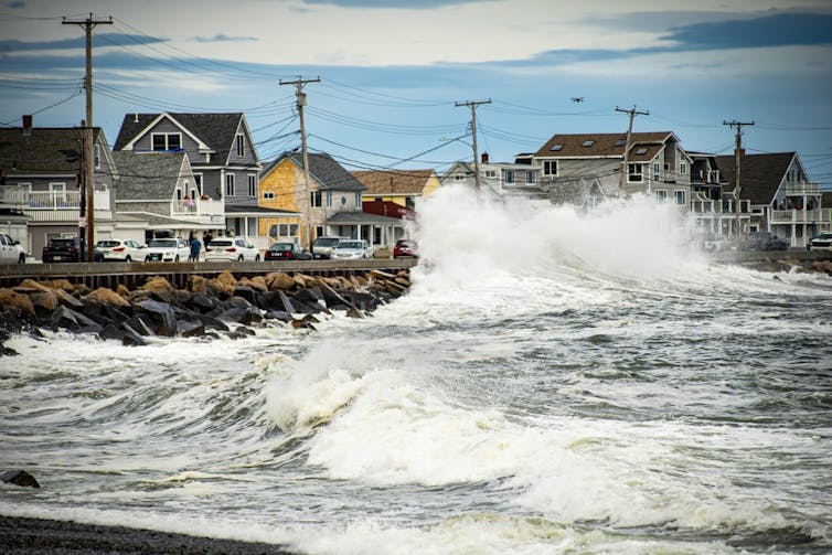 Sea spraying over seaside houses