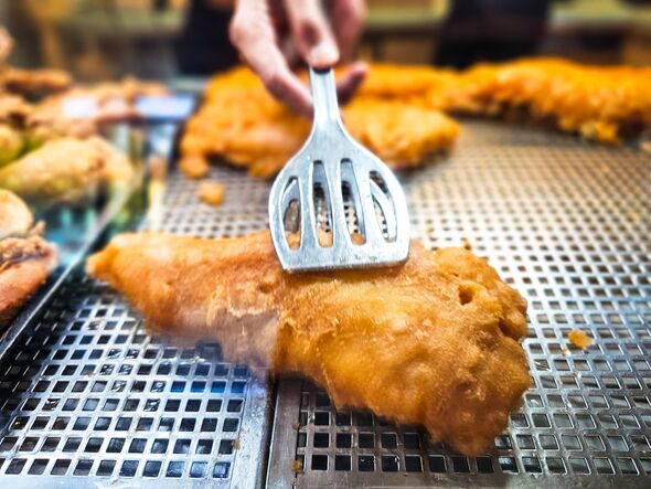 Battered fish on display and for sale at the fish and chip shop. Battered fish on display and for sale at the fish and chip shop.