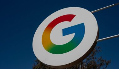 A large sign with Google's "G" logo hangs outside during the daytime.