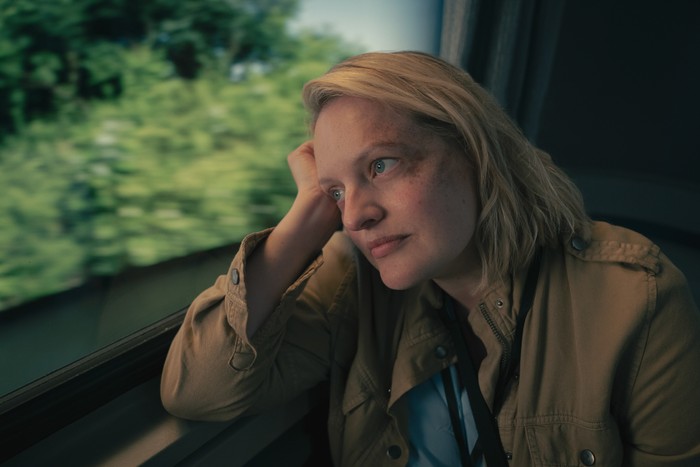 Elisabeth Moss as June in The Handmaid's Tale Elisabeth Moss as June in The Handmaid's Tale, sitting on a train and staring out the window.