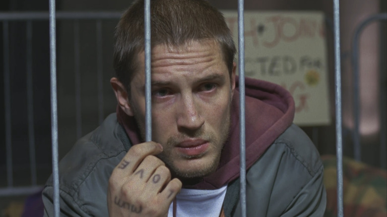 Tom Hardy's Stuart Clive Shorter is seen in closup looking through prison bars in Stuart A Life Backwards