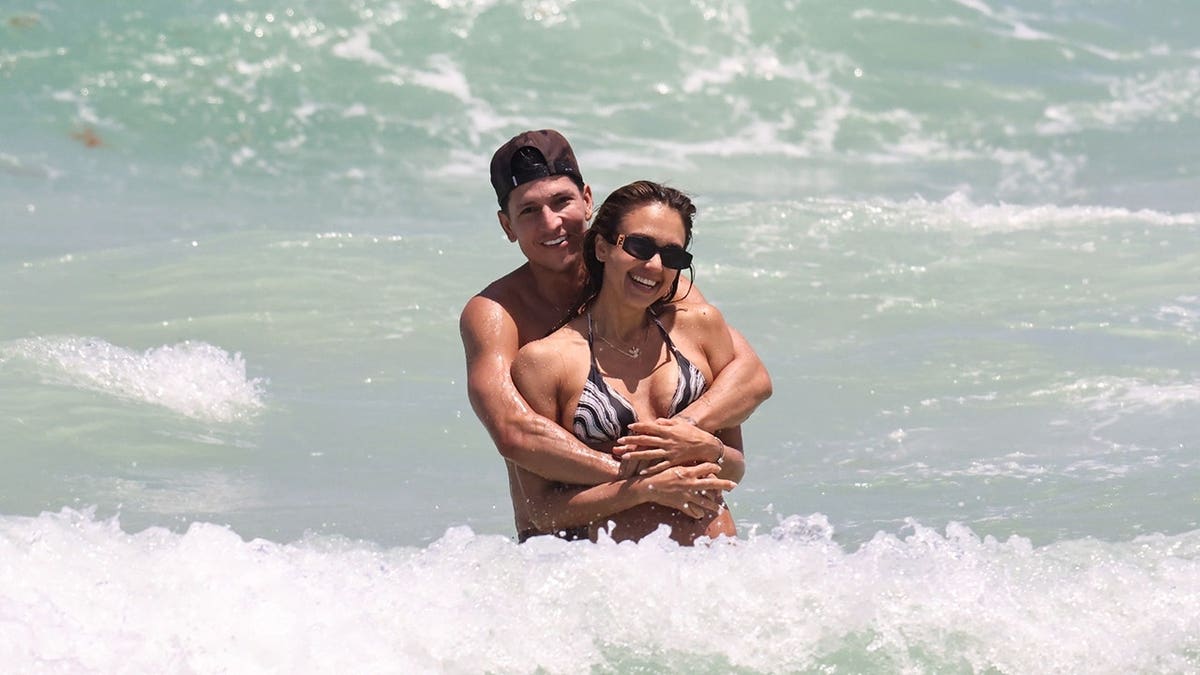 Danny Ramirez hugging Jessica Alba from behind while in the ocean in Miami in May 2026.