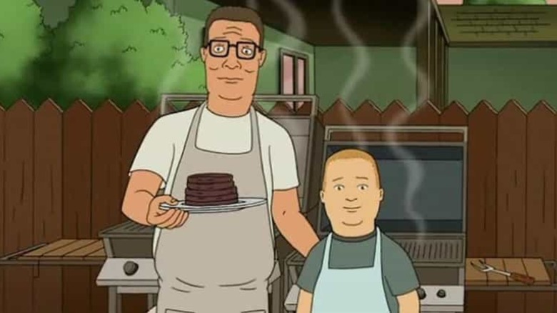 Hank and Bobby look out from the grill at a backyard cookout in King of the Hill.