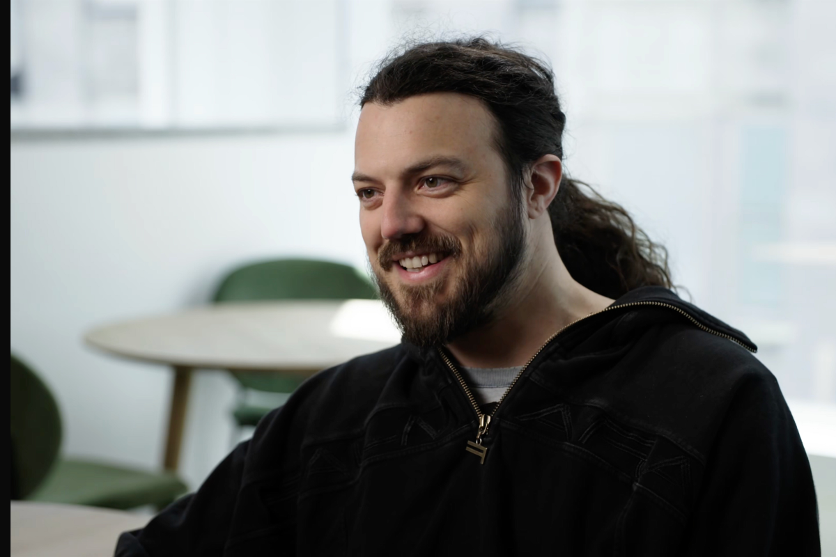 A caucasian man with long dark hair and a full beard