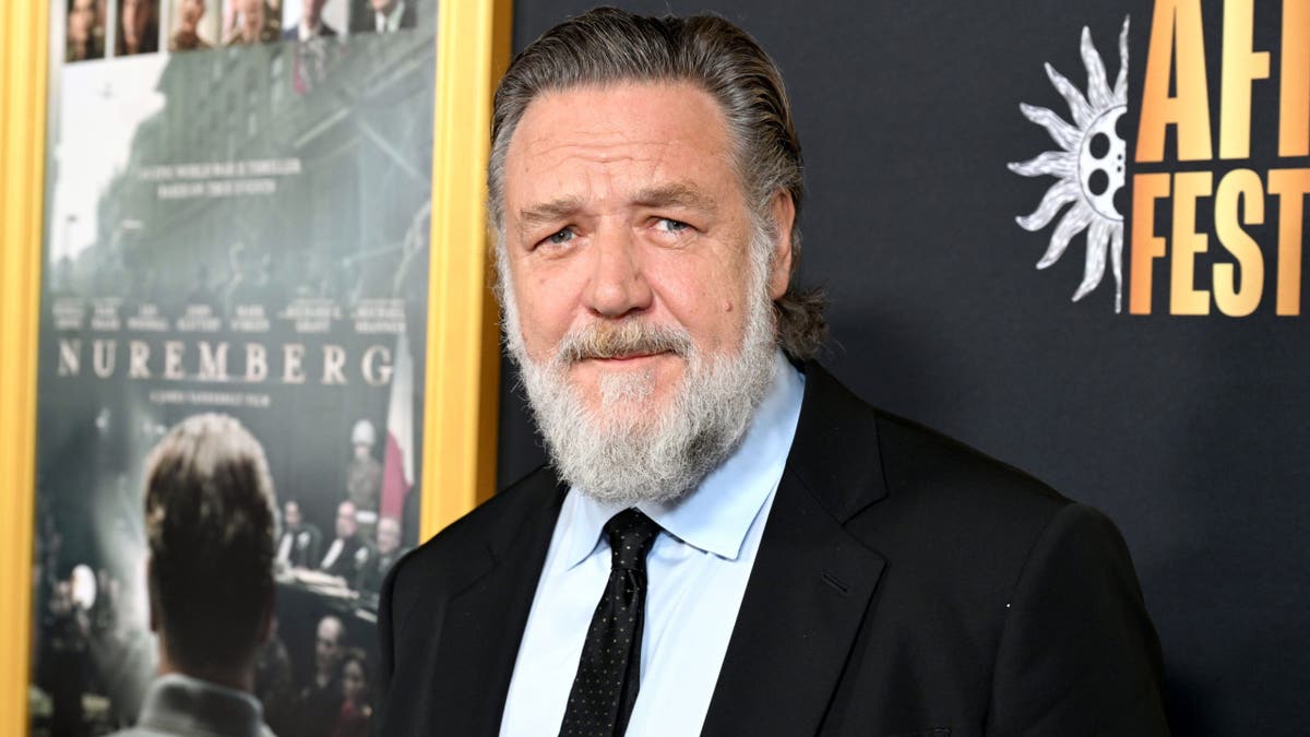 Russell Crowe in a suit and tie sporting a beard.