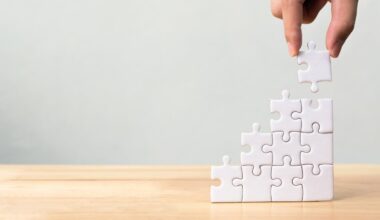 A hand building a puzzle vertically.