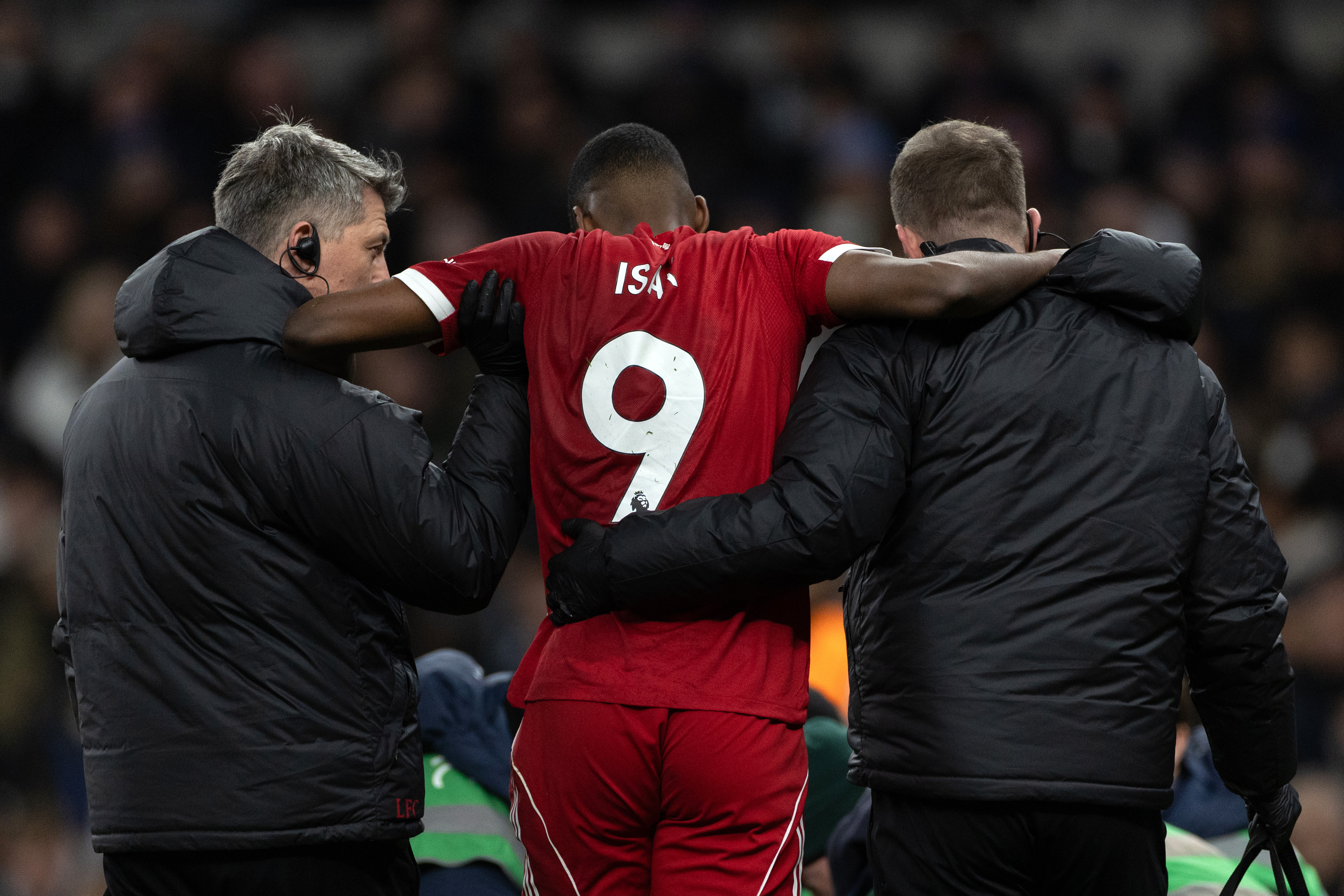 Alexander Isak of Liverpool is assisted off the pitch by medical staff after going down injured during the Premier League match between Tottenham Hotspur and Liverpool.