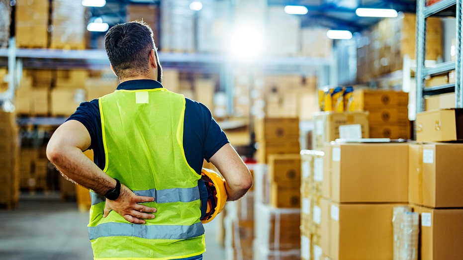 A warehouse worker is pictured next to boxes.