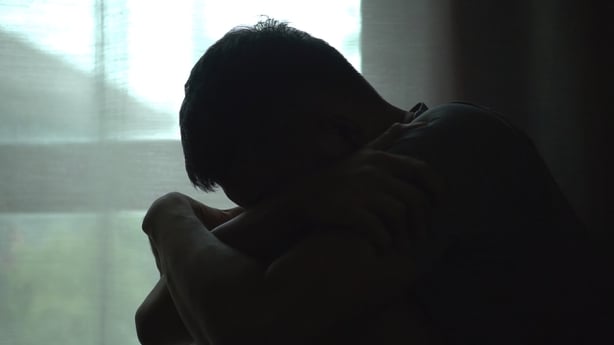 Silhouette of man sitting alone by window dark room , head in their hands, feelings of sadness,depression,hopelessness ,Mental Distress Consept.