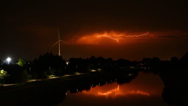 Lightnings flashes in the clouds as a severe storm looms over a canal in Sint-Pieters-Leeuw