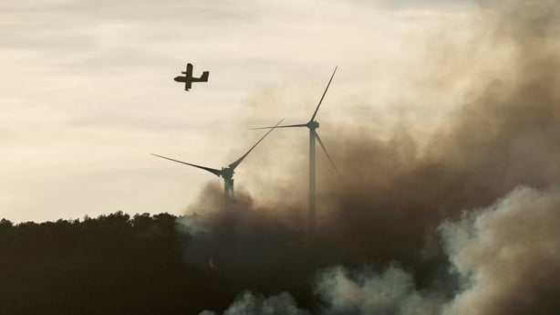 This photograph shows a Canadair CL-415 of the French civil security flying over a wildfire 