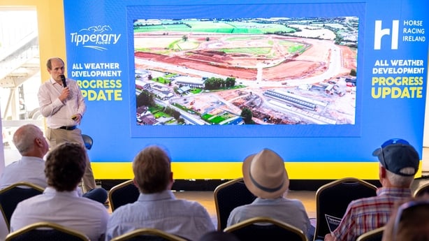 A seated crowd watch a presentation on the development of a Tipperary racecourse