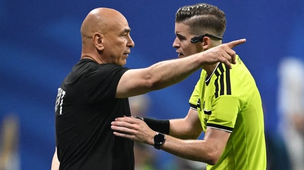 Egypt's head coach Hossam Hassan speaks with French referee Francois Letexier 