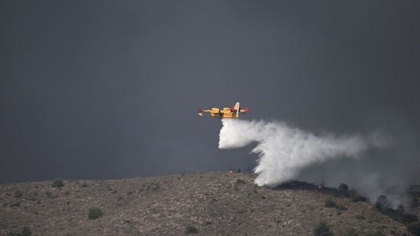 A seaplane is seen extinguishing a wildfire in Spain