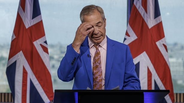 Nigel Farage, flanked by union jack flags, speaks during a press conference