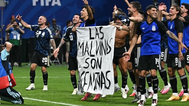 Argentina's players hold a banner reading "The Malvinas (Falkland Islands) belong to Argentina," after winning the 2026 World Cup football tournament semi-final match with England