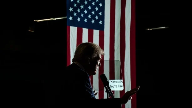 A teleprompter reading "Kamala Harris You're Fired" is seen in 2024