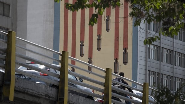 Vehicles are move along a bridge beneath an anti-US mural. depicting an American flag decorated with bombs, in Tehran, Iran, on July 16, 2026
