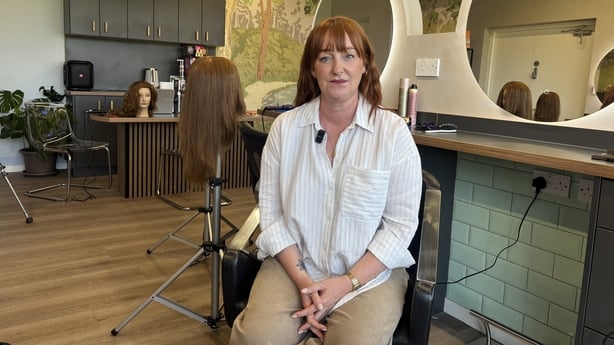 Woman sitting and posing for a photo in a hair salon
