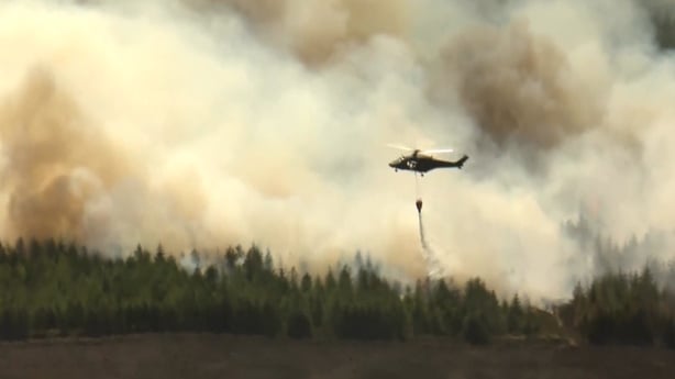Irish Air Corps helicopter provides aerial support by dropping water over the wildfire