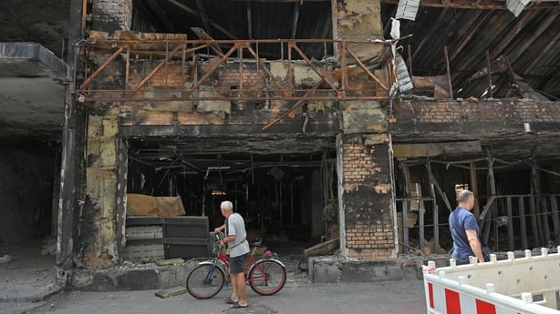 A man with a bicycle looks at a building in the Lukianivka neighbourhood damaged in one of the Russian attacks, Kyiv, Ukraine, on July 21, 2026