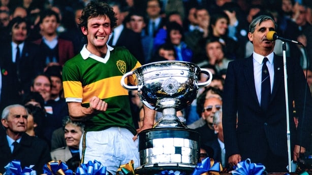 Kerry captain Ambrose O'Donovan, in the company of GAA President Paddy Buggy, winks as he prepares to lift the Sam Maguire Cup in 1984