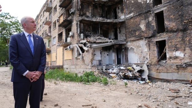 Taoiseach Micheal Martin stands somberly during a visit to the bomb damaged Lukianivska district of Kyiv, Ukraine