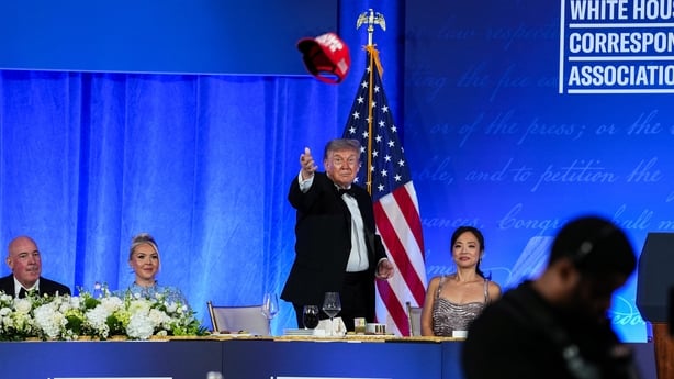 US President Donald Trump tosses his TRUMP 2028 hat to an attendee during the re-scheduled White House Correspondents Dinner in the Presidential Ballroom at the Waldorf Astoria on July 24, 2026 in Washington, D