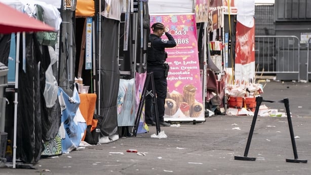 A police officer stands near abandoned vendor booths after a shooting occurred at the Bite of Seattle food festival