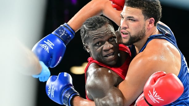 Uganda's Aziz Abdul (red) takes on England's Damar Thomas (blue)