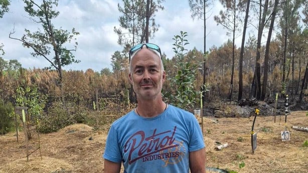 A man in blue stands in front of a field in France 