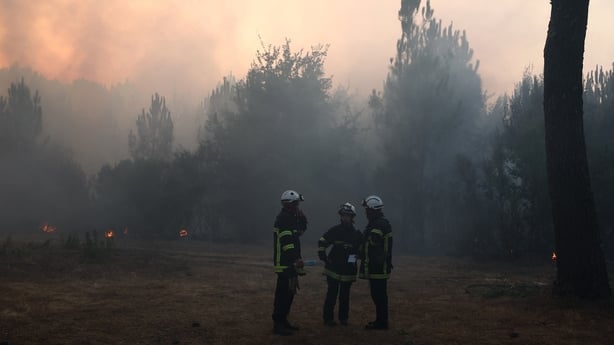 Firefighters speak with each other amid the smoke in Claouey, north of the Arcachon Basin