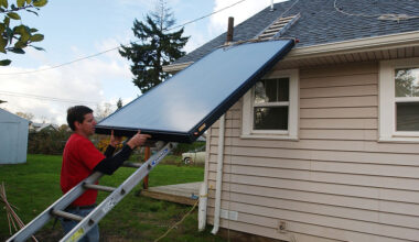 A man installs solar panels for a domestic hot water system in Salem, Oregon.