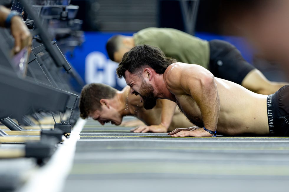 Athletes performing intense push-ups during a fitness competition. Athletes performing intense push-ups during a fitness competition.