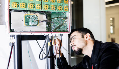 Tamerlan Aghayev examines a circuit board and wires.