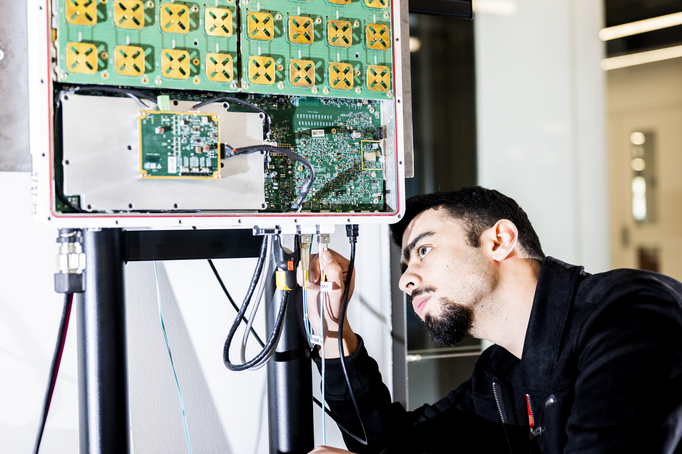 Tamerlan Aghayev examines a circuit board and wires.