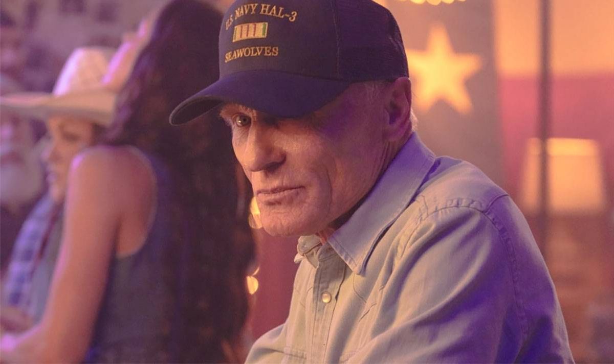 A man in a baseball cap looks serious