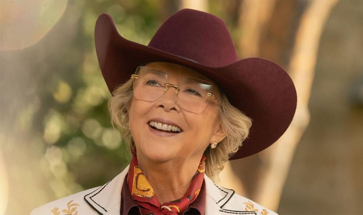 A woman in a cowboy hat smiles